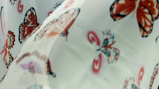 White fabric with beautiful butterflies falls, fluttering on a black background. Macro. Slow mo, slow motion, high speed camera, 200fps
