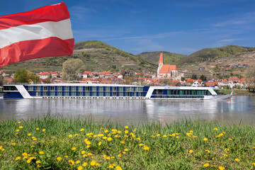 Weissenkirchen village with Austrian flag and boat on Danube river in Wachau, Austria
