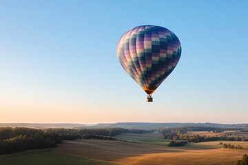 Fototapeta premium vibrant hot air balloon soars over serene landscape at sunrise casting rich shadows on fields below with ample negative