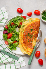 Cheese omelette with fresh green salad and toast on a plate