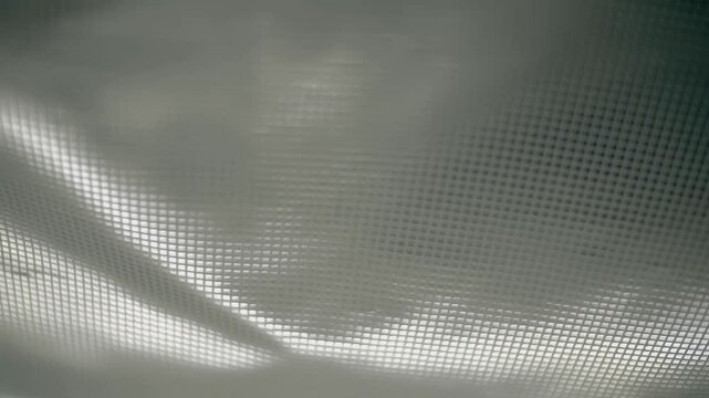 Fabric with a shiny checkered pattern flutters in the wind. Closeup. Macro. Slow mo, slow motion, high speed camera, 200fps
