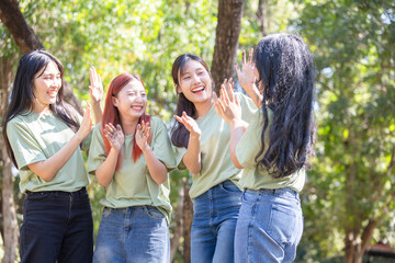 Happy women volunteers team showing dirty hands outdoors, Cheerful young Asian multigenerational group enjoying outdoor teamwork