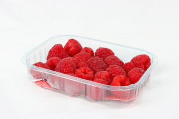 Tray of raspberries isolated on a white background.