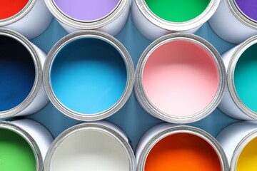 Cans of different paints on light blue background, closeup