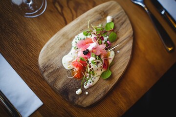 A beautifully arranged dish features vibrant toppings on a wooden platter