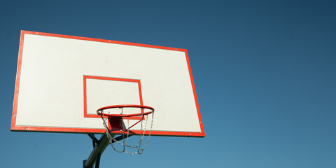Basketball backboard hoop on sports court against clear blue sky. Banner. Outdoors. Summer game. Copy space. Mock up. © svetlana_cherruty