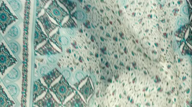 Fabric with beautiful floral and geometric patterns falls, fluttering on a black background. Closeup. Macro. Closeup. Macro. Slow mo, slow motion, high speed camera, 200fps