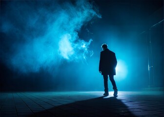 Lonely Silhouette of a Man Walking at Night in a Mystical Blue Fog