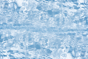Blue water with ripples on the surface. Defocus blurred transparent blue colored clear calm water surface texture with splashes and bubbles. Water waves with shining pattern texture background.