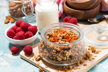 homemade granola with dried apricots and nuts in a jar for breakfast, closeup