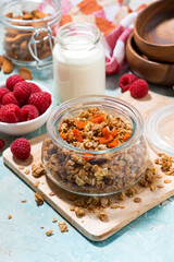homemade granola with dried apricots and nuts in a jar for breakfast, vertical