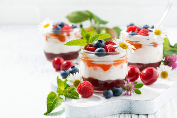 sweet dessert with jam, cream and fresh fruit, white background