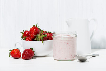 sweet strawberry yogurt and fresh berries on a white table