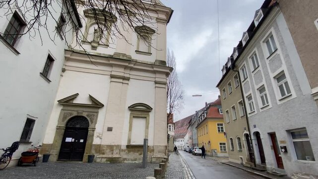 A walk through the historical city center of Regensburg, Germany, featuring old architecture, cobbled streets, and a cloudy sky. A blend of history and everyday life.