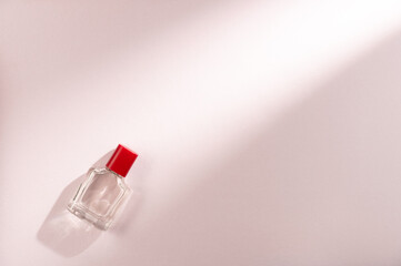 Bottle of perfume on a pink background. Flat lay, top view. Copy space