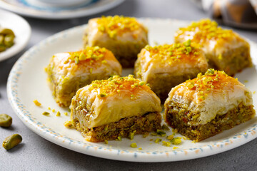 Turkish dessert baklava on a white plate. Grey background. Close up.
