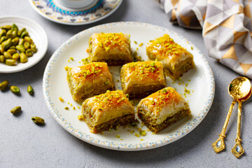 Turkish dessert baklava on a white plate. Grey background. Close up.