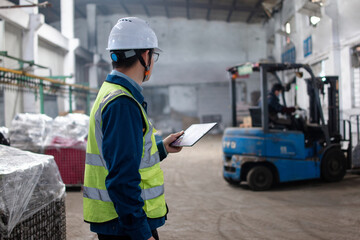 Asian male workers are using tablet computers to handle shipments in the warehouse