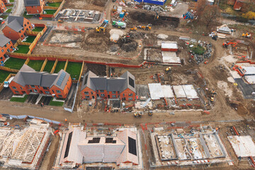 Aerial view from drone at Construction activity in a housing development as multiple homes take...