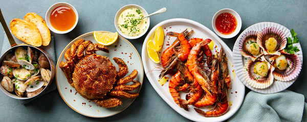 Seafood assortment. Prawns, crab, oysters, langoustines, scallops on blue background. Close up. Top view.
