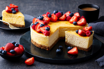 Cheesecake dessert with fresh berries and cup of coffee. Grey background. Close up.