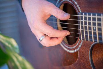 This is a beautiful view of someone playing an acoustic guitar in a closeup shot