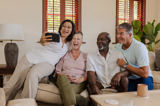 Happy diverse senior Friends taking selfie together on cozy living room sofa