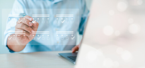 assessment survey online. Businessman with evaluating questionnaire on online laptop computer....