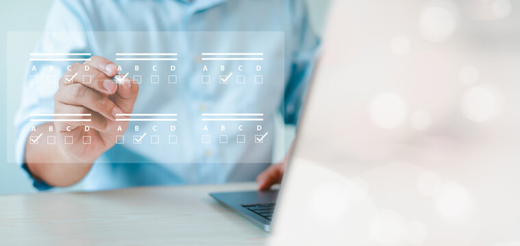 assessment survey online. Businessman with evaluating questionnaire on online laptop computer. choose correct answer in test, questions test, online exam, quiz knowledge, filling out an survey form. - Powered by Adobe