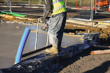 Construction worker leveling concrete at a building site