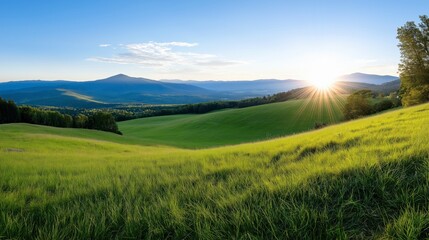 Obraz premium Scenic Sunrise Over Rolling Green Hills and Distant Mountains