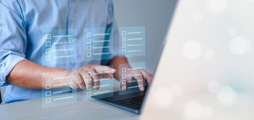 assessment survey online. Businessman with evaluating questionnaire on online laptop computer....