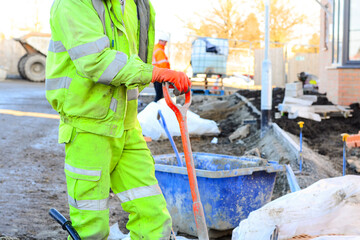 Construction worker wearing safety gear and using shovel