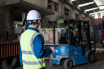 Asian male workers are using tablet computers to handle shipments in the warehouse