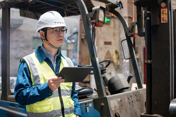 Asian male workers are using tablet computers to handle shipments in the warehouse
