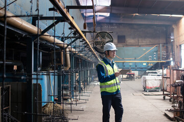 Asian male workers are working with digital tablet in the electroplating workshop.