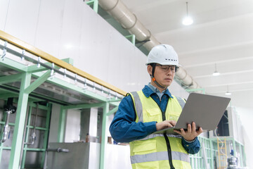 asian engineer working with laptop in factory