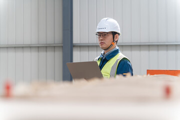 asian engineer working with laptop in factory