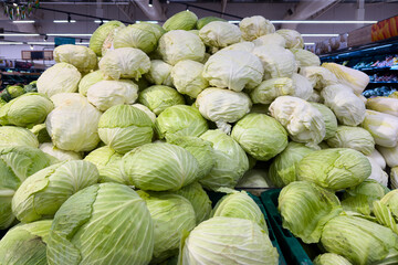 Fototapeta premium A pile of fresh cabbages neatly stacked in a supermarket.
