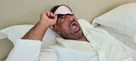 Worried frightened young man and sleep mask