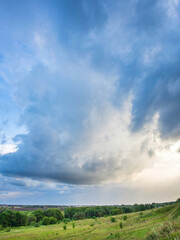 Cloudy sky with a few trees in the background