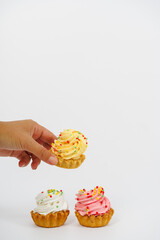 Three shortbread cakes with cream. One cake in a woman's hand. White background.
