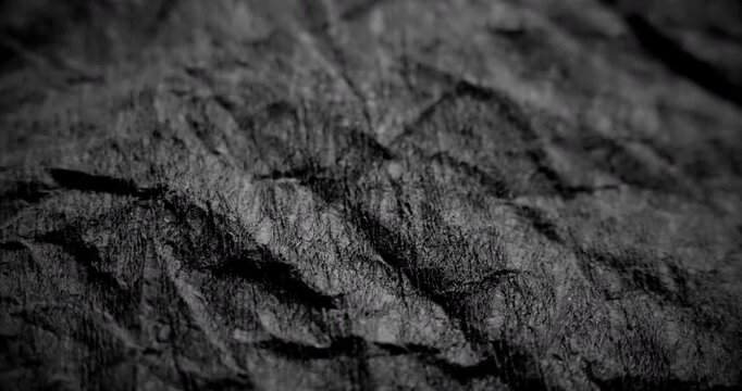 Dark crumpled surface in slow linear drift.
Rough black texture glides steadily with gritty depth in gentle motion. Ideal for abstract ads in 4K.

