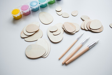 Art supplies with wooden egg shapes brushes and paints for creative projects