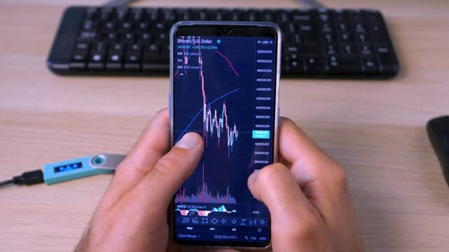 A trader watches the chart of a cryptocurrency and trades on the exchange