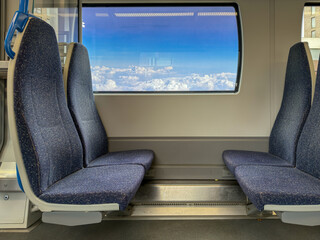 Empty Train Seats Facing Window with Scenic Cloud View