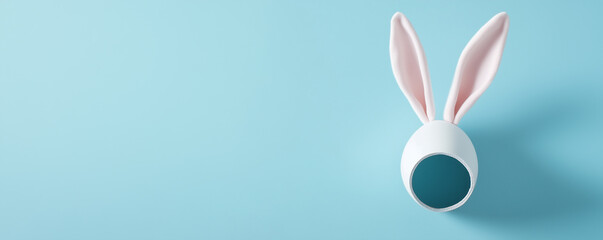 Naklejka premium Głowa królika wystająca z sziiury w kartce, motyw wielkanocny. Rabbit head sticking out of a hole in a piece of paper, Easter motif.