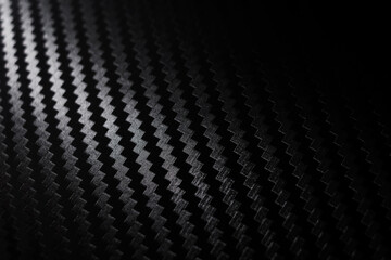 Carbon fiber composite raw material background. Carbon fiber texture. Dark Gray background with lighting.	
