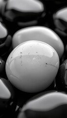 Naklejka premium A close-up, black and white shot of smooth, glossy pebbles, creating a minimalist and elegant pattern, evoking a sense of calm and natural simplicity.