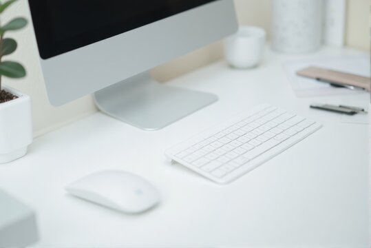 Minimalist white desk setup with iMac, wireless keyboard and mouse for a clean and modern workspace aesthetic